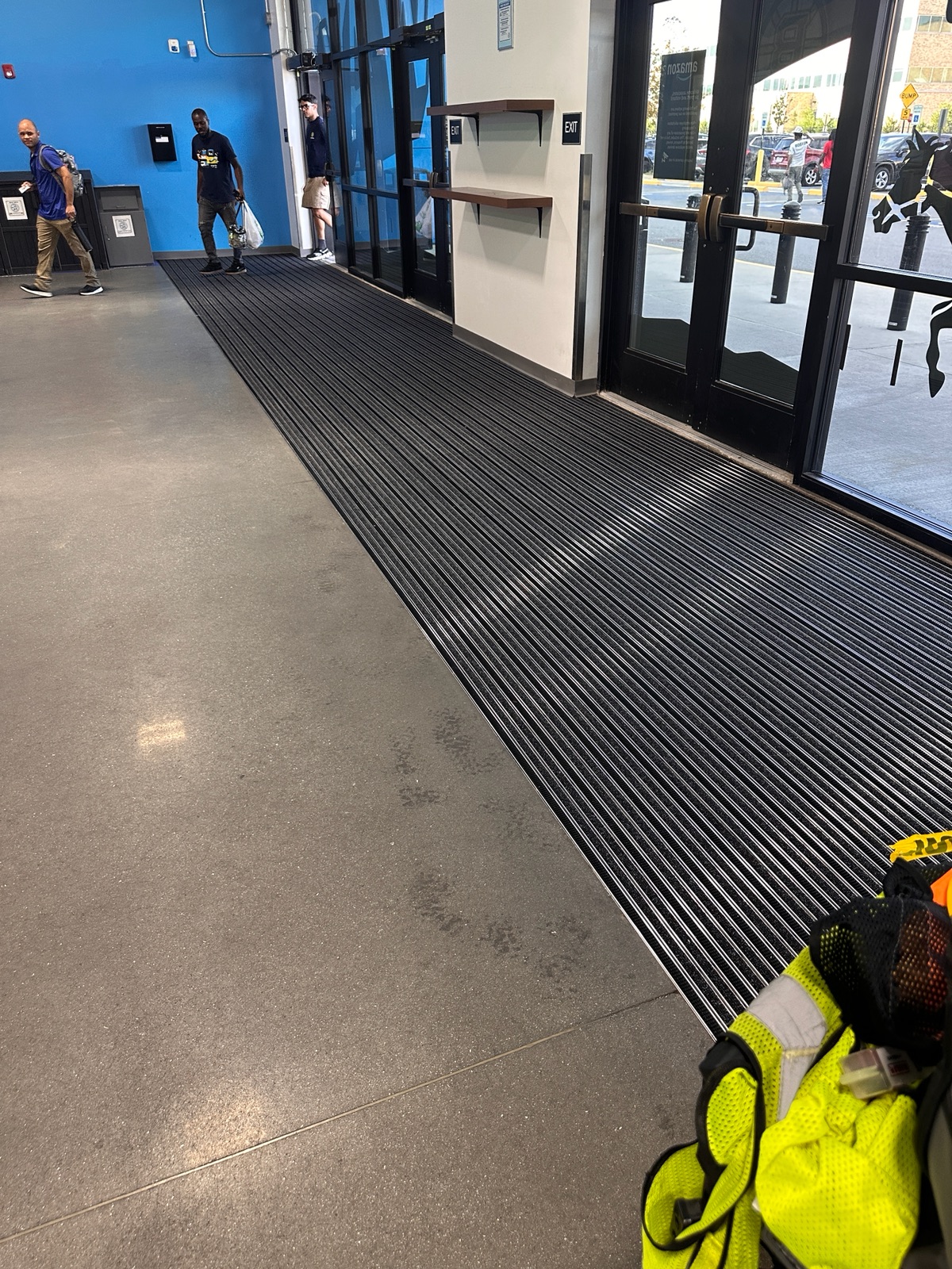 Custom aluminum entry matting system with carpet and brush inserts set flush at a facility entrance